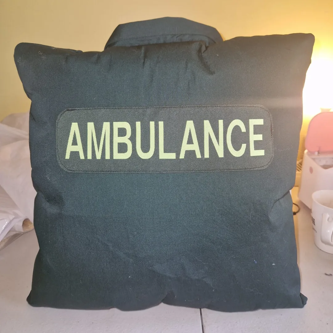 Memory cushion made from a dark green ambulance service uniform shirt with the reflective Ambulance panel on the front